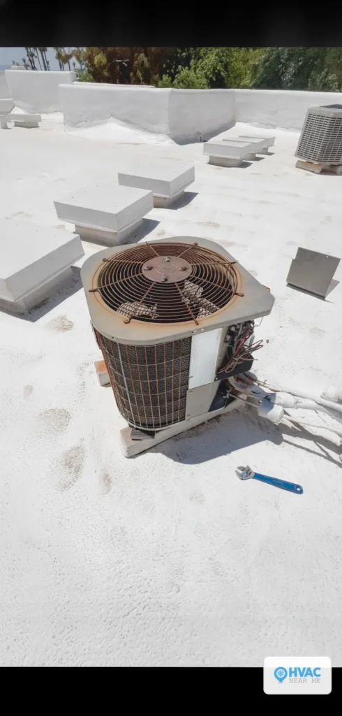 HVAC Near Me technician's wrench in frame beside a newly installed rooftop package AC unit